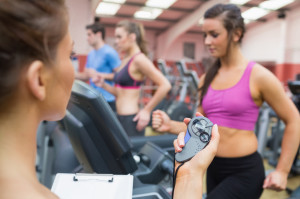 Female instructor using stopwatch in the gym